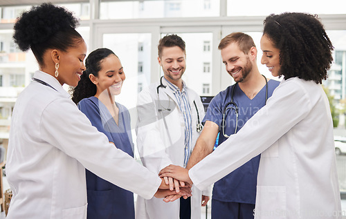 Image of Doctors, teamwork and hands together in meeting, motivation or unity in healthcare together at hospital. Happy group of medical professionals piling in team building, support or goals at the clinic