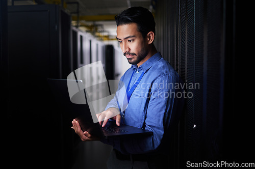 Image of Man, server room and laptop of programming, system management and data center solution or coding at night. Business person engineering on computer, information technology and power check in basement