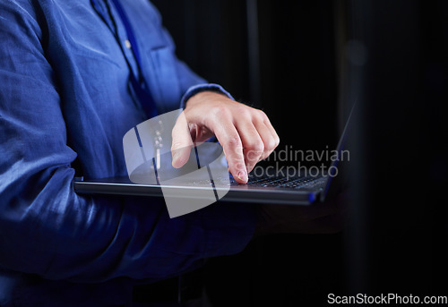 Image of Hands, laptop and typing on keyboard for programming to work on project at night. Information technology, computer and person coding, networking and software developer of system admin on internet