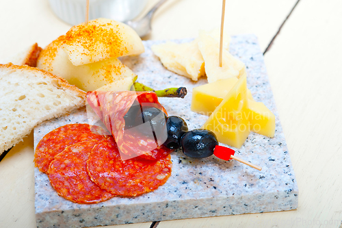 Image of mix cold cut on a stone with fresh pears