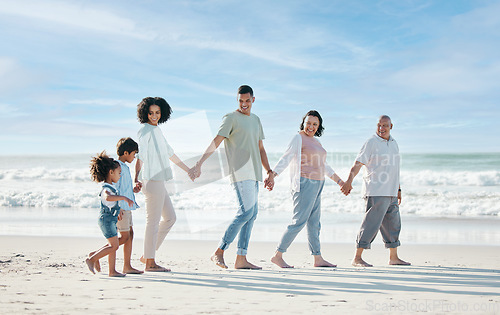 Image of Summer, beach and a family holding hands while walking on the sand by the ocean or sea together. Grandparents, parents and children outdoor in nature for travel, vacation or holiday on the coast