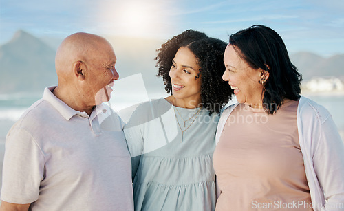 Image of Happy, beach and woman with her senior parents on a family vacation, holiday or adventure. Love, smile and young female person talking to her elderly mother and father by the ocean on a weekend trip.