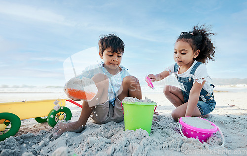 Image of Boy, girl and shovel with bucket, beach sand and digging for playing, outdoor and vacation in summer. Kids, siblings and plastic toys for sandcastle, construction game and together on holiday by sea