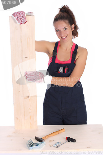 Image of woman carpenter holding wooden plank