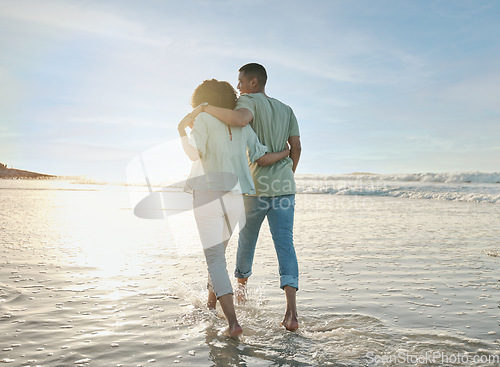 Image of Love, hug and back of couple at the beach walking, bond and relax in nature on blue sky background. Ocean, love and rear view of man embrace woman at sea for travel, freedom and romantic walk in Bali