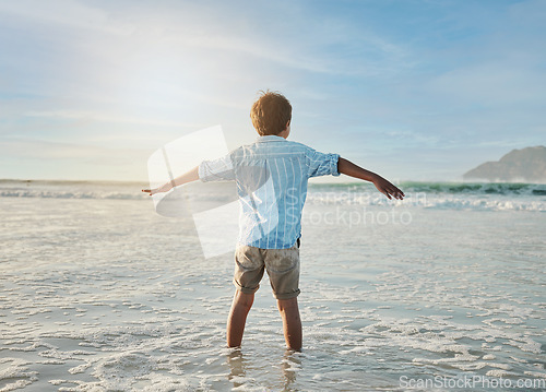 Image of Freedom, fun and child in waves at beach, playful on tropical summer holiday in Australia with blue sky. Ocean, adventure and sun, back of boy in water and playing with energy on island vacation