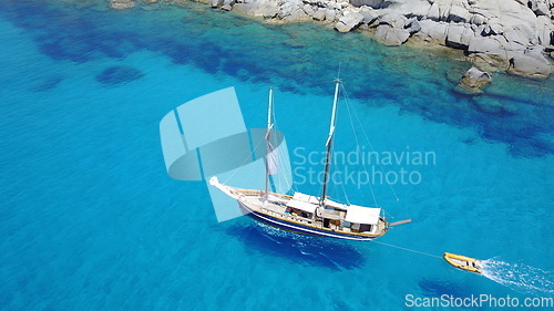 Image of Boat, sailing in blue water and summer sun on ocean holiday, relax in freedom and nature. Yacht vacation, aerial of travel and tropical cruise on adventure to Greek island with sunshine, fun and sea.