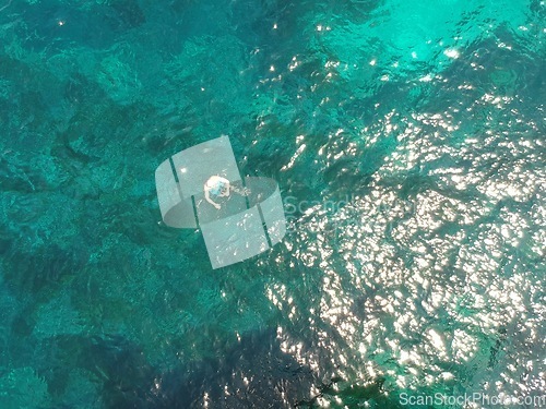 Image of Above, swimming and a person in the ocean in summer for a beach vacation, travel or relax in the water. Nature, sunshine and a man in the sea for stress relief, holiday or happy with a drone view