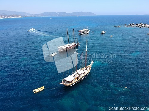 Image of Aerial boat, sailing in Greece and summer sun on ocean holiday, relax in freedom and nature. Yacht vacation, travel and tropical cruise on sea adventure tour to Greek island on blue sky and water.