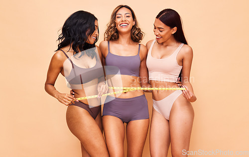 Image of Girl friends, underwear and measuring tape in studio portrait for laugh, wellness and diversity by background. Women group, healthy body and lingerie to lose weight, help or transformation with pride