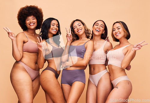 Image of Body positive, peace sign and portrait of women in studio in underwear for wellness, beauty and self love campaign. Diversity, emoji and people on brown background for natural, skincare and inclusion