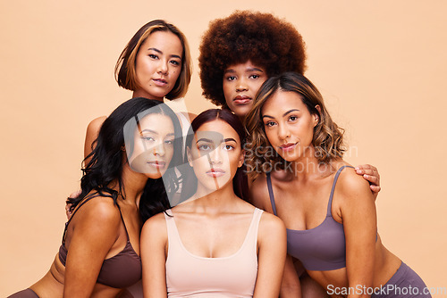 Image of Diversity, beauty and portrait, group of women with self love and solidarity in studio together. Cosmetics on face, power people on beige background with underwear, skincare and makeup for equality.