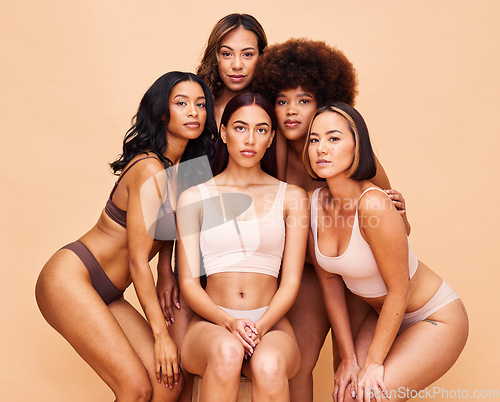 Image of Diversity, beauty and portrait of women with body positivity, self love and solidarity in studio together. Serious face, group of people on beige background in underwear, skincare and cosmetic makeup