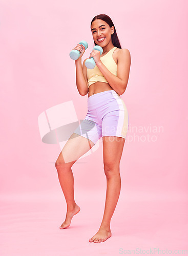 Image of Fitness, portrait and woman with dumbbell in studio for healthy body, exercise and strong on pink background. Happy young sports model training to lose weight for workout, performance and challenge