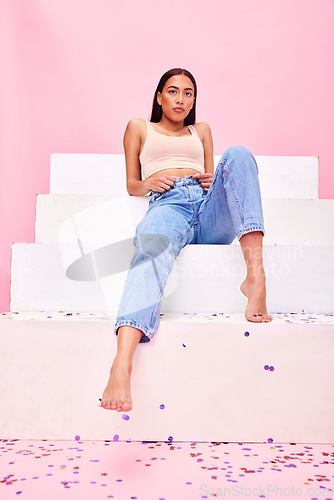 Image of Woman, confetti and steps portrait with relax, style and fashion with celebration sparkle. Studio, pink background and female model with party, event and birthday decoration with gen z confidence