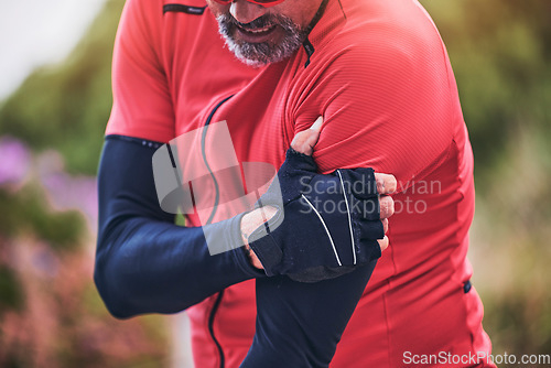 Image of Man, cyclist and arm injury in sports accident, emergency or broken bone on mountain road in nature. Closeup of male person or athlete with sore pain, ache or joint inflammation from cycling or fall