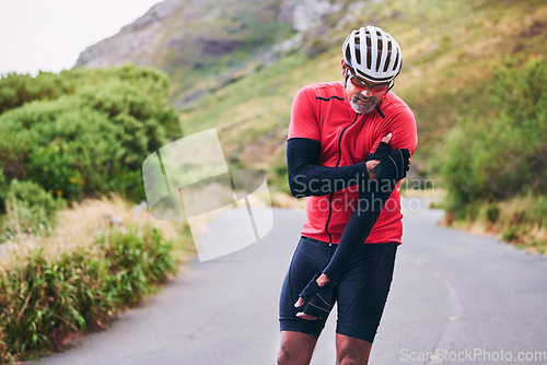 Image of Man, cyclist and arm injury in fitness accident, emergency or broken bone on mountain road in nature. Male person or athlete with sore pain, ache or inflammation on joint in sports fall or cycling