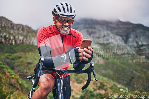 Image of Happy man, cyclist and phone on mountain bicycle in communication, social media or networking in nature. Male person or athlete smile on mobile smartphone app in sports workout, fitness or cycling