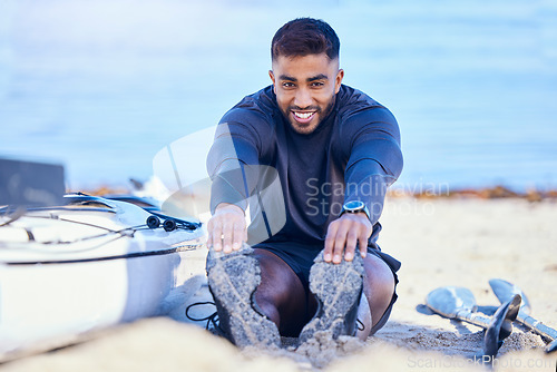 Image of Portrait, beach and man stretching legs to start workout, training and kayak exercise for sports. Happy, athlete and person warm up at ocean to prepare for fitness, healthy body and flexible outdoor