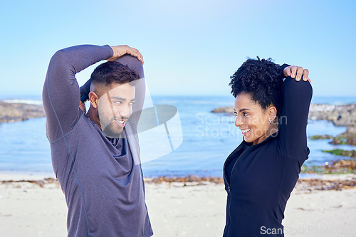 Image of Beach, exercise and happy couple of friends stretching for fitness, teamwork and start workout performance, routine or arm care. Sea, eye contact and team partner doing warm up, wellness or training