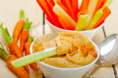 Image of fresh hummus dip with raw carrot and celery