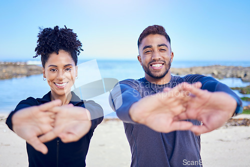 Image of Portrait, beach and couple stretching, fitness and exercise with training, warm up and runner with wellness. Healthy people, man and woman stretch, seaside and workout with sports, ocean and energy