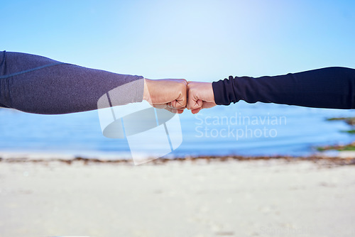 Image of Fitness, couple and fist bump on the beach for exercise, outdoor workout or celebration in water sports, teamwork and cardio. People, hands and sign of collaboration together in support or success