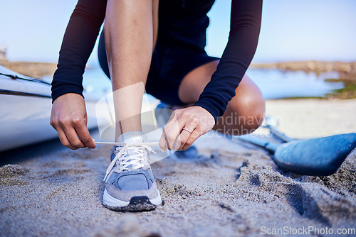 Image of Hands tie shoes, beach and athlete start workout, training and kayak exercise outdoor. Sand, person and tying sneakers at ocean to prepare in fitness, sports and healthy body for wellness in summer.