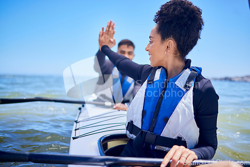 Image of Water, high five with man and woman in kayak winning at lake, beach or river race for exercise challenge. Ocean holiday, adventure and fitness, happy couple celebrate in canoe for achievement at sea.