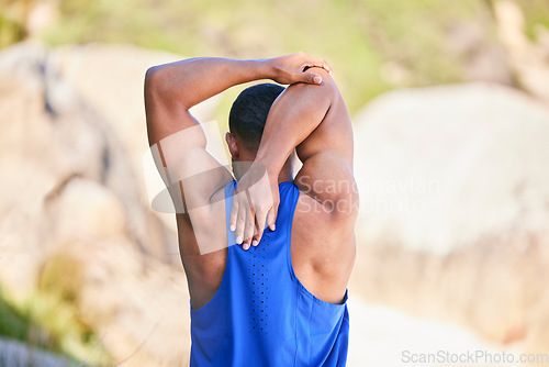 Image of Man, fitness and back in stretching on beach for workout, exercise or outdoor training in sports. Rear view of muscular, athlete or sporty male person in body warm up on the ocean coast in nature