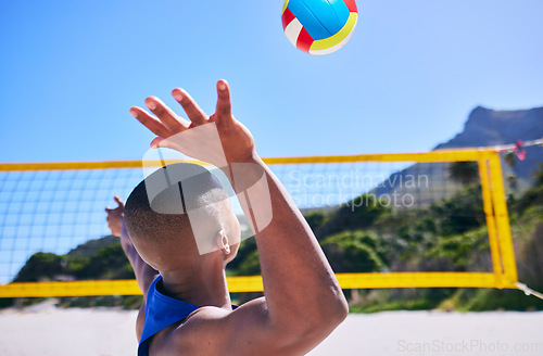 Image of Summer beach, sports and person serve volley ball, play competition and player training, workout or exercise. Blue sky, tropical island and back of athlete start game, action or practice challenge