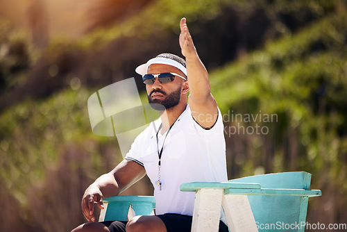 Image of Summer, sports and a volleyball referee on the beach in a chair for authority, rules or regulations during a game. Health, professional or competition with a man refereeing a match outdoor in the day