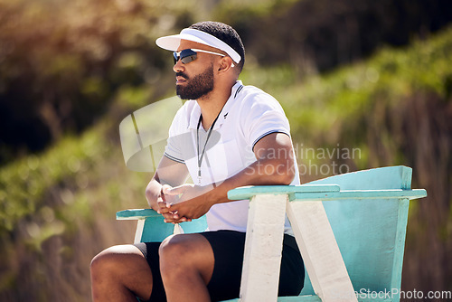 Image of Summer, sports and a volleyball referee in a chair on the beach for authority, rules or regulations during a game. Health, professional or competition with a serious man refereeing a match in the day