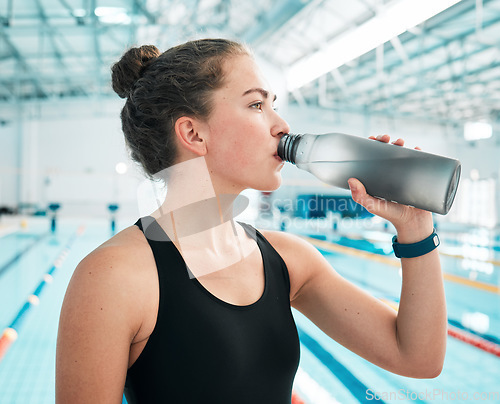 Image of Swimmer, sports or woman drinking water to relax on break after exercise, workout or fitness training. Hydrate, thinking or girl athlete with liquid bottle for wellness or health by swimming pool