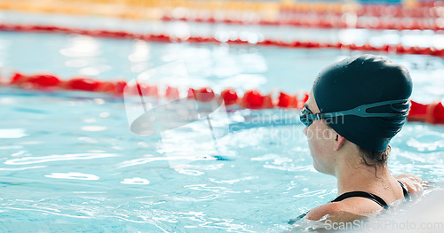 Image of Woman, pool and swimming in water at start for sports fitness, race or training and practice. Active female person, athlete or professional swimmer getting ready for lap, workout or indoor exercise