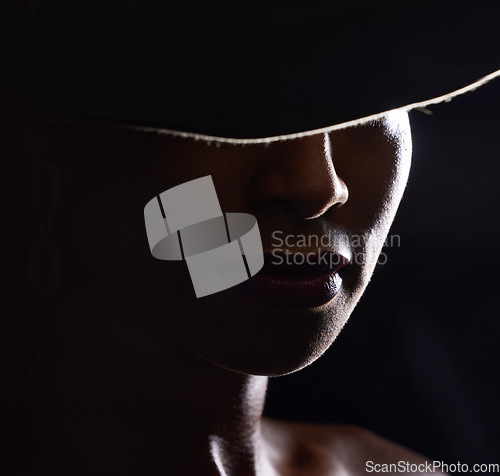 Image of Woman, dark studio and hat for fashion, beauty and mystery with style, design or closeup headshot. Girl, model and black background for fantasy, night aesthetic or makeup for edgy, sexy woman and art