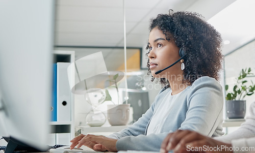 Image of Crm, contact us or black woman in call center at customer services for a communication or telemarketing agency. Computer, microphone or African consultant talking, helping or speaking at office desk