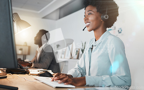 Image of Call center, black woman and typing with computer, smile and focus for telemarketing, crm and help desk. Customer support expert, woman and reading on pc, web or internet for communication in Houston