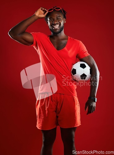 Image of Black man, soccer ball and football in studio with happiness and red clothes with sunglasses and a positive mindset for sports. Portrait of a male from France happy and laughing in summer fashion