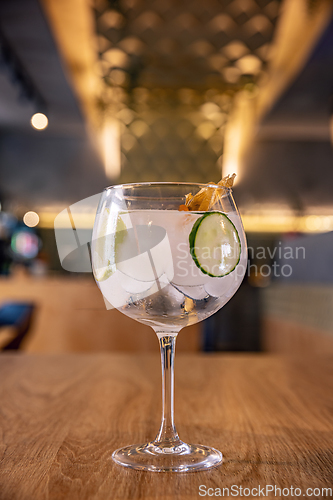 Image of Gin tonic cocktail with sliced cucumber