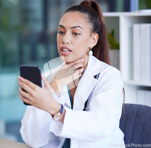 Image of Phone, video call and doctor doing a consultation online for healthcare in her office at the hospital. Communication, technology and female medical worker consulting on a cellphone in medicare clinic