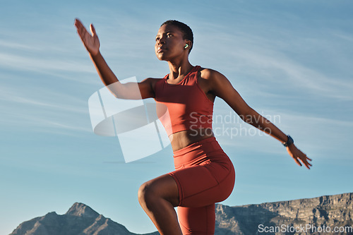 Image of Black woman runner, mountain and balance in outdoor nature for fitness, health and wellness to start morning. Woman, stretching and exercise by mountains with music, focus and workout in Cape Town