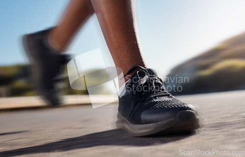 Image of Fitness shoes, run and training workout of a woman running on a road fast in nature. Marathon, sport and asphalt street runner doing exercise, sports or speed on concrete outdoor doing cardio