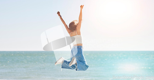 Image of Happy woman, freedom and jump at beach with arms stretching for purpose, energy and motivation. Back view, success and fun at sea, summer vacation and sunshine travel, hope and wellness celebration