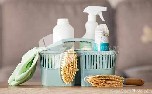 Image of Product, basket and cleaning with a brush, supplies or detergent on a wooden table surface for housework. Bacteria, living room and empty room with a container of disinfectant in a house or home