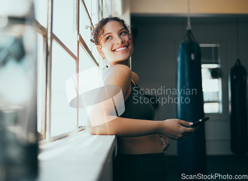 Image of Window, smartphone and woman in gym, smile and online for training schedule, motivation and achievement. Happy, female athlete and girl with cellphone, break and connection for website and wellness