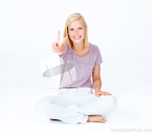 Image of Happy woman, portrait or peace sign for good luck, positive energy or sitting optimism on white studio background. Smile, model or cool hand gesture for playful, fun or comic expression on backdrop