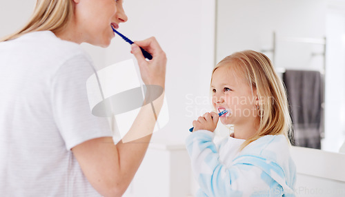 Image of Development, mother and girl in bathroom with brush for teeth doing bonding, embrace and loving together. Female parent, lady and kid or child brushing teeth, dental hygiene and child growth at home.