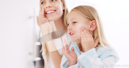 Image of Skincare, mother and daughter home spa day washing their face in bathroom or apply beauty product, lotion or face mask while bonding at home. Happy woman and girl child doing morning skin routine