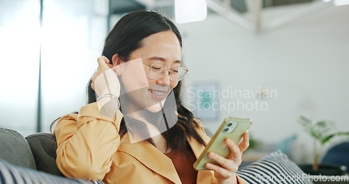 Image of Phone communication, talking and asian woman at home on a sofa with a online conversation. Phone call, speaking and networking of a person on a mobile phone at a living room house on a couch